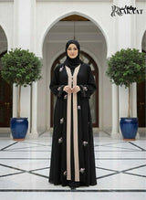 White Embroidered Abaya đ€ A0002 worn by a model in an elegant setting with floral embroidery details.