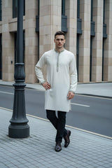 Model wearing The Alabaster Heritage Panjabi P0009 in ivory with intricate embroidery, standing on an urban street.