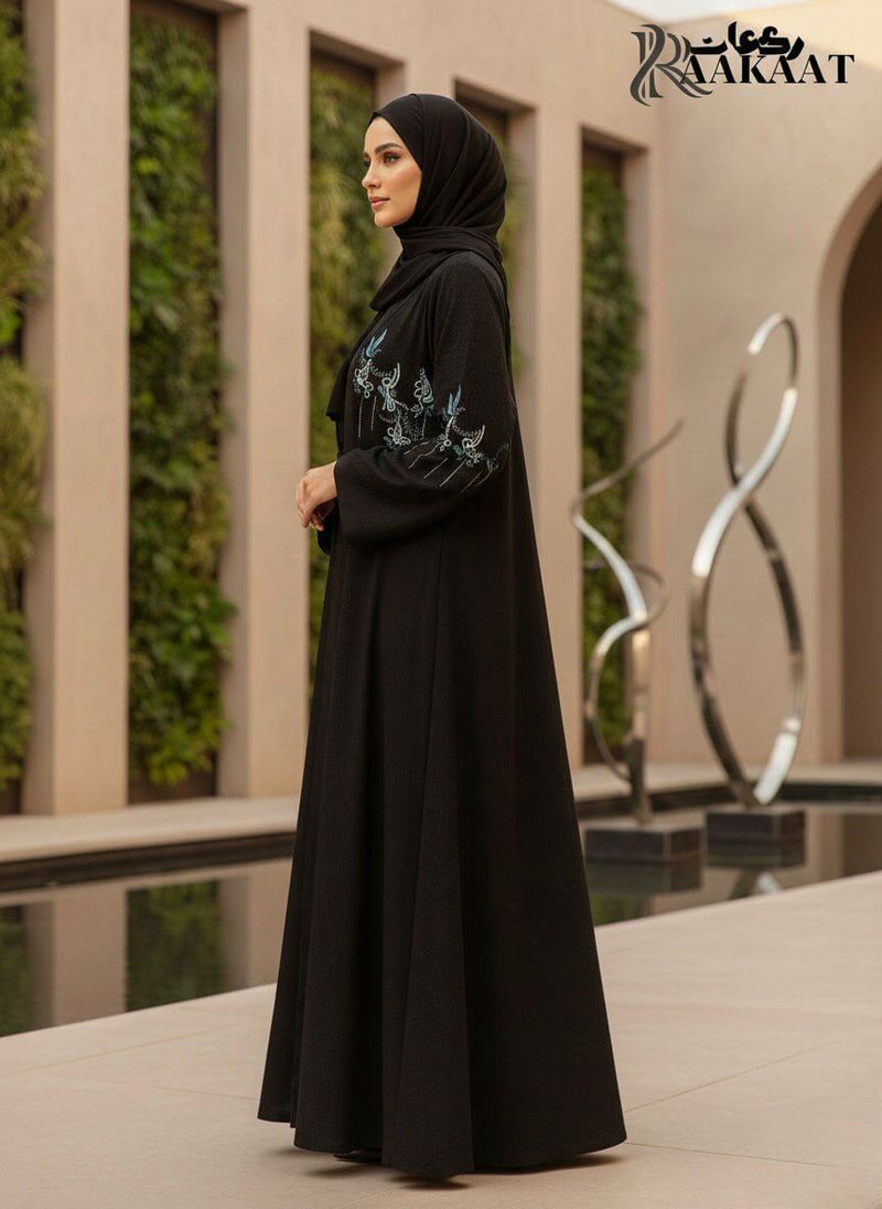 Elegant Black Floral Embroidered Open Abaya with Soft Draped Fit  A0008 worn by a model in an outdoor setting.