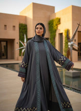 Elegant Grey Embroidered Open Abaya with Geometric Borders A0006 worn in a stylish outdoor setting.