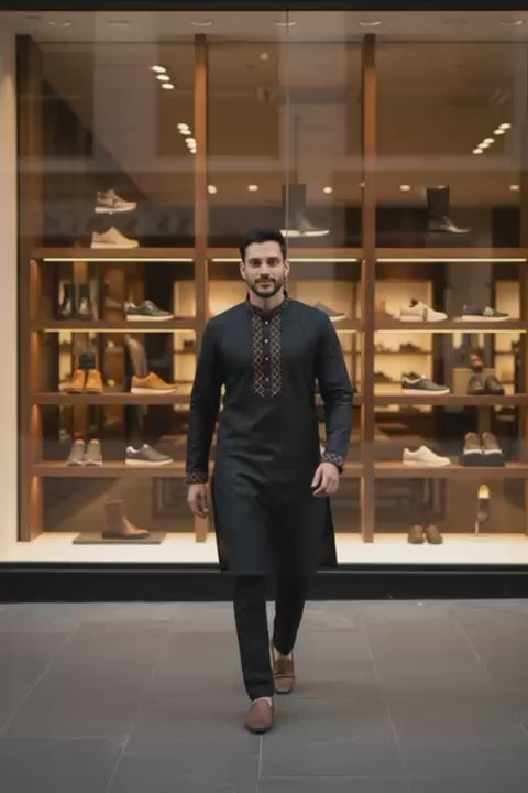 Classic Black Bangladeshi Panjabi with Elegant Golden Embroidery P0002 worn by a man walking in a stylish shoe store.