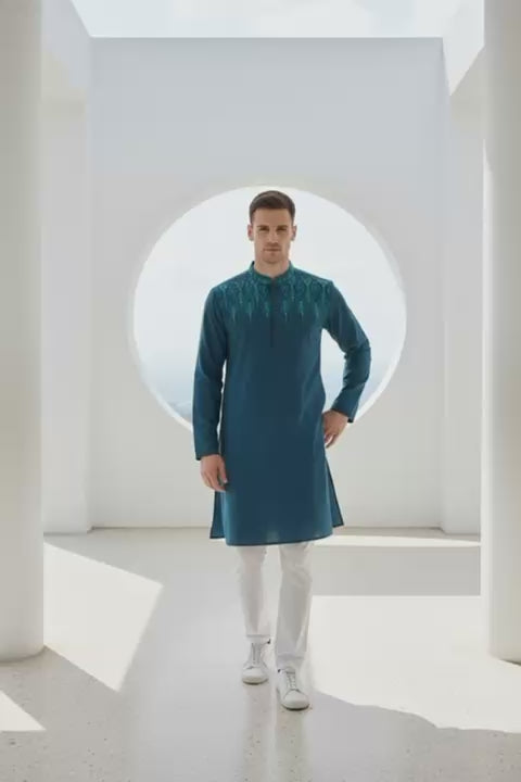 The Azure Horizon Embroidered Panjabi P0007 modeled in a modern setting, showcasing emerald fabric and intricate embroidery.