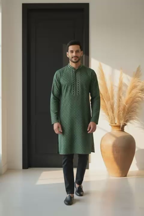 The Emerald Geometric Luxe Panjabi P0008 modeling a moss green outfit with tonal geometric patterns in a modern setting.